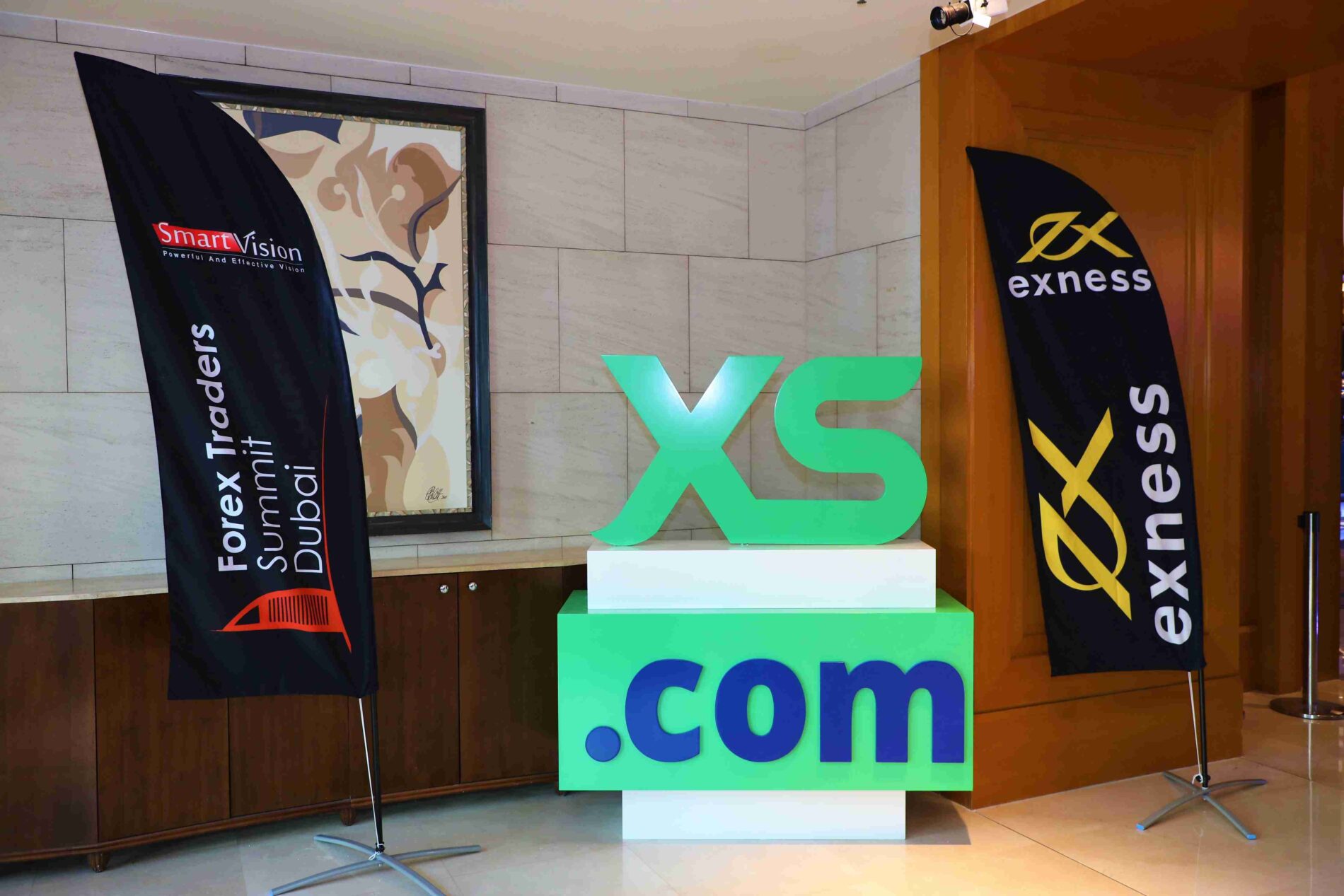 Forex Traders Summit Dubai 2023: Display featuring flags from Smart Vision and Exness, alongside a prominent XS.com logo.