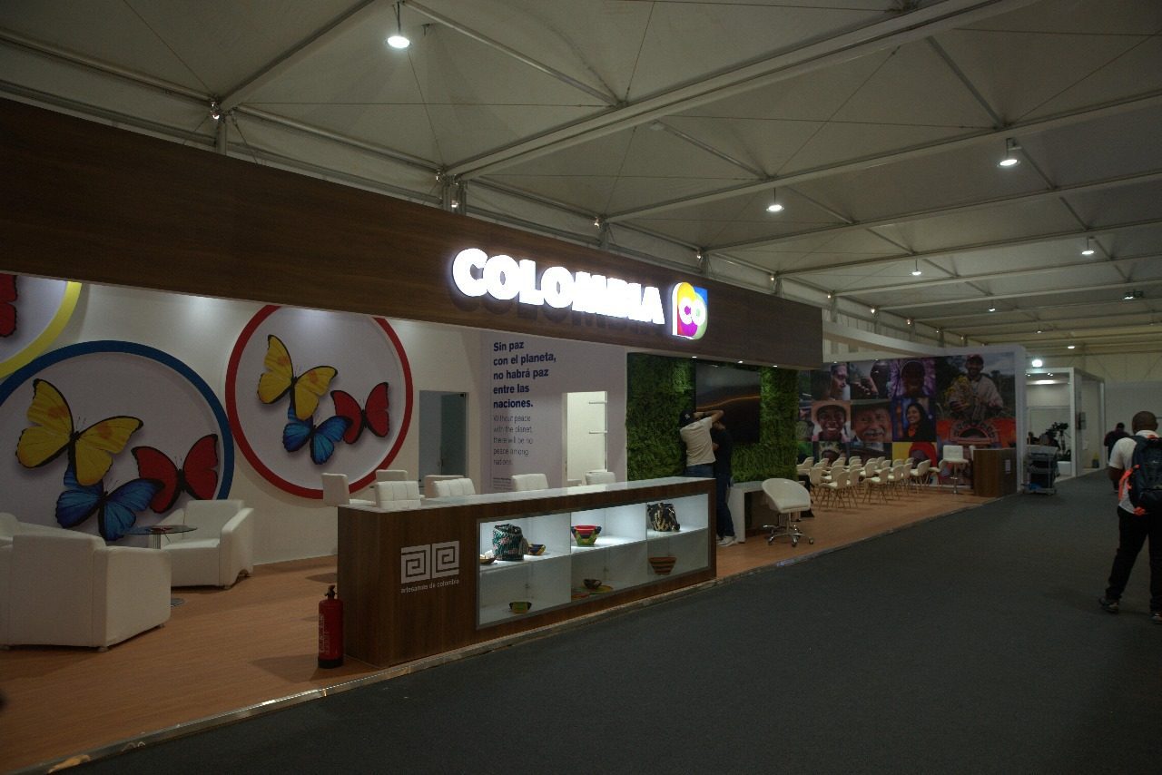 Colombia booth at COP27 in Sharm El Sheikh, featuring a vibrant display with lush greenery, cultural motifs, and information on Colombia’s environmental initiatives and commitment to biodiversity and sustainability.