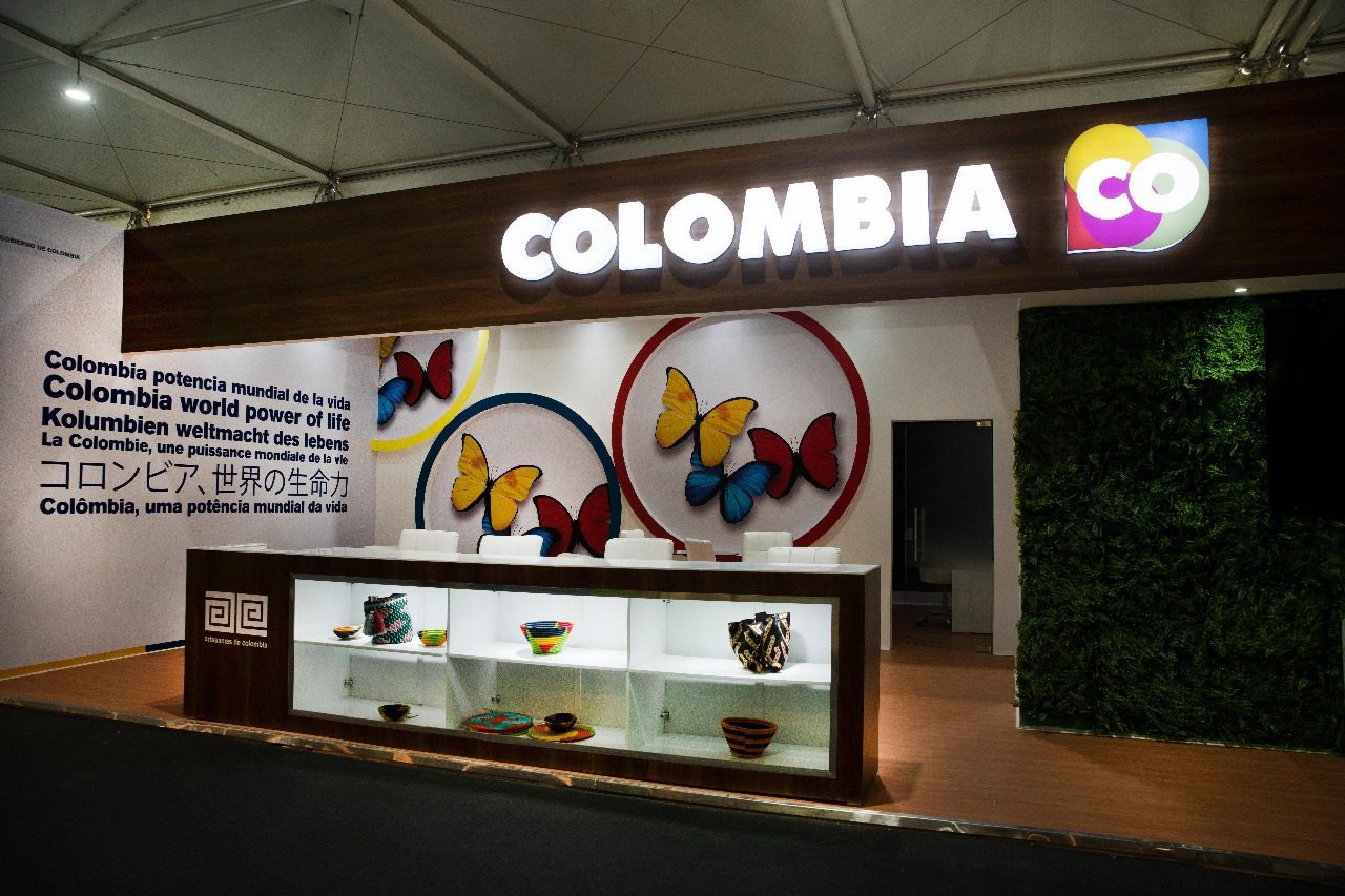 Colombia booth at COP27 in Sharm El Sheikh, featuring a vibrant display with lush greenery, cultural motifs, and information on Colombia’s environmental initiatives and commitment to biodiversity and sustainability.
