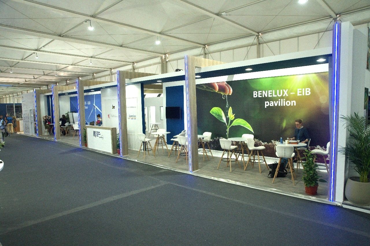 European Investment Bank (EIB) booth at COP27 in Sharm El Sheikh, featuring a sleek, professional design with digital displays and informational materials highlighting EIB's role in financing sustainable projects and climate initiatives worldwide.