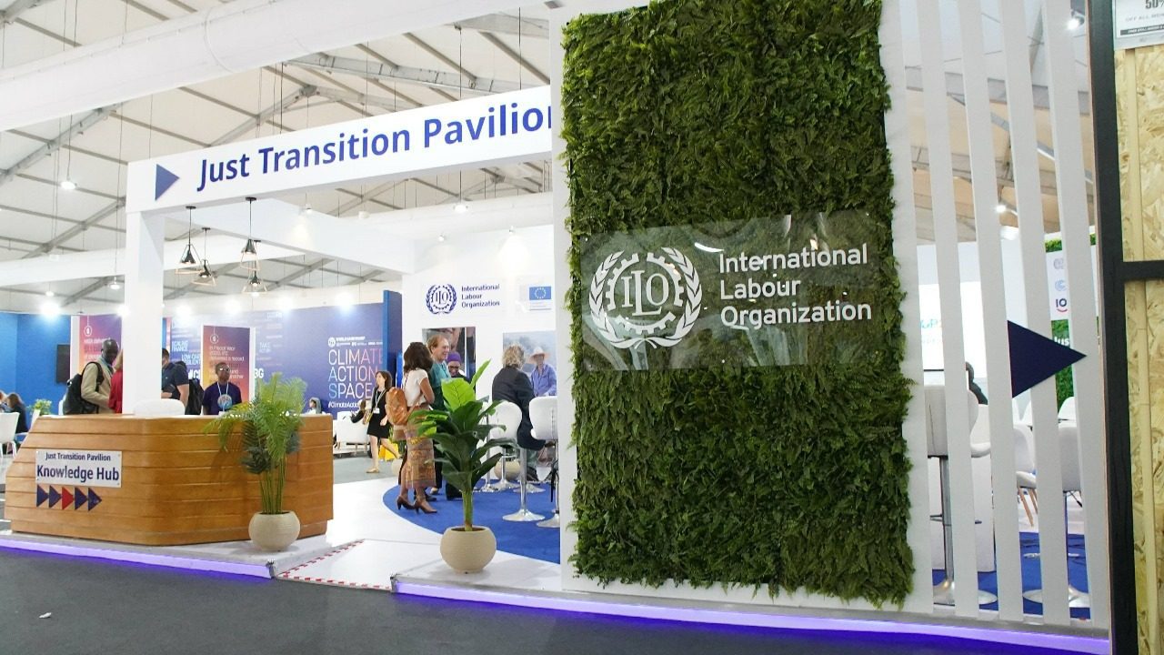 ILO (International Labour Organization) booth at COP27 in Sharm El Sheikh, displaying a professional setup with interactive panels and visuals focusing on labor rights and sustainable development, emphasizing the ILO’s commitment to fair work practices and climate resilience.