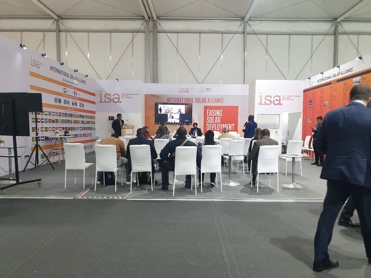 ISA (International Solar Alliance) booth at COP27 in Sharm El Sheikh, featuring a modern design with solar energy-themed displays and interactive elements, highlighting the ISA's efforts to promote solar power and renewable energy solutions globally.