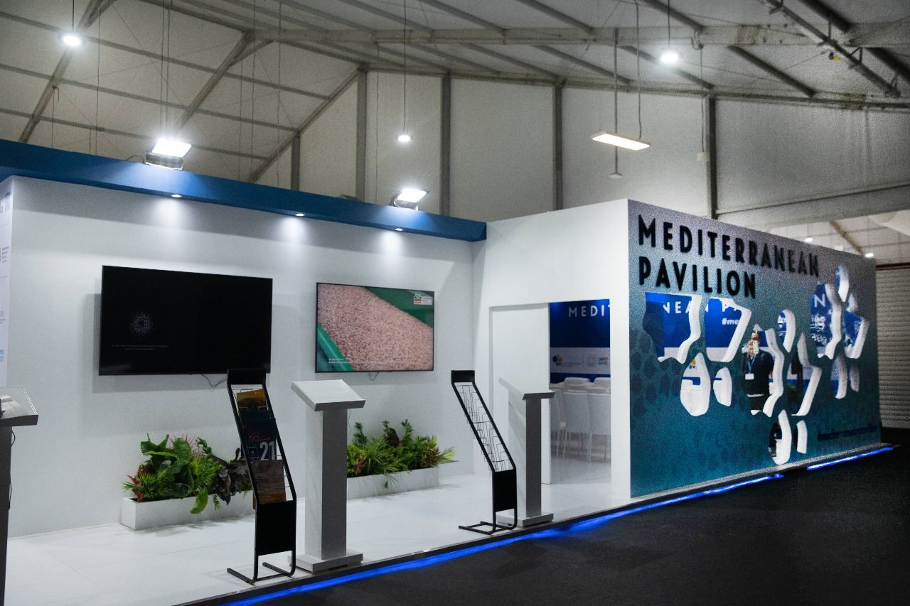 Mediterranean booth at COP27 in Sharm El Sheikh, highlighting the region’s environmental and climate initiatives with vibrant displays, maps, and visuals that showcase collaborative efforts to address climate change and promote sustainability in the Mediterranean area.