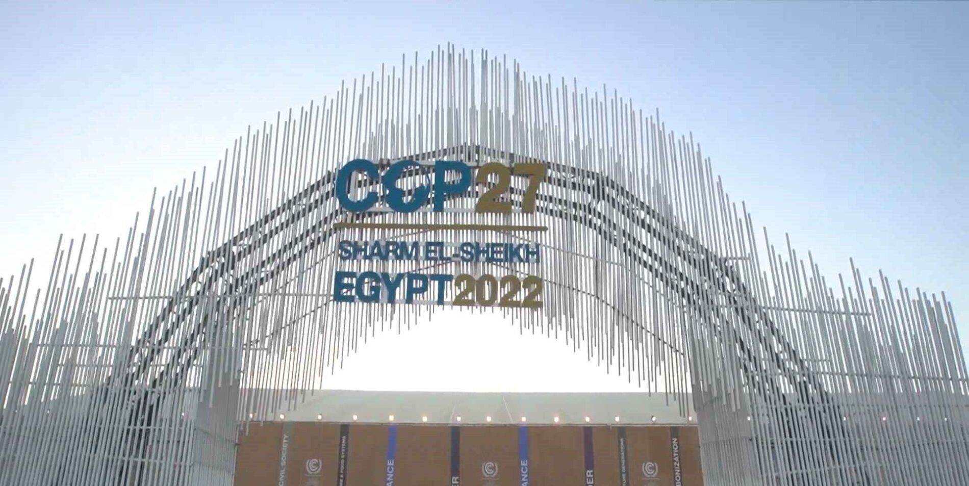 Entrance gate of COP27 expo in Sharm El Sheikh, featuring a modern, eco-friendly design with vibrant banners and welcoming signage reflecting the event's focus on climate action.