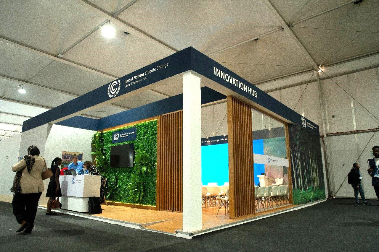 UNFCCC (United Nations Framework Convention on Climate Change) booth at COP27 in Sharm El Sheikh, displaying an engaging setup with informative panels and digital screens that focus on global climate policies, agreements, and the UNFCCC's role in international climate action.